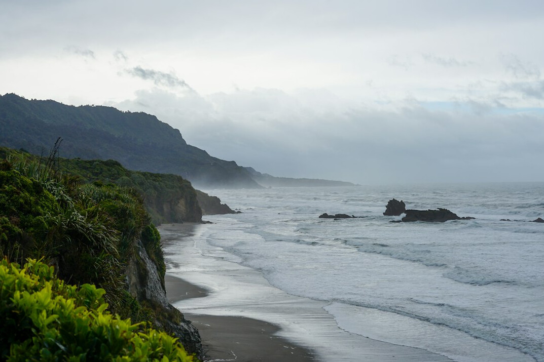 Misty rocky cliffs along a quiet coastline
