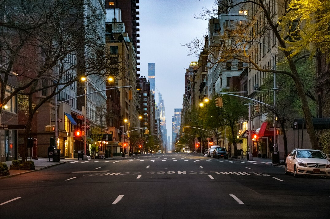 City street at dusk with warm lights from windows