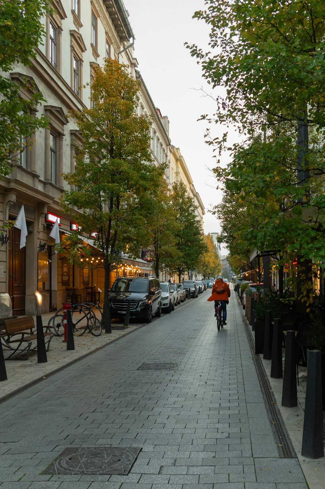 Cyclist riding down a quiet cobbled city street