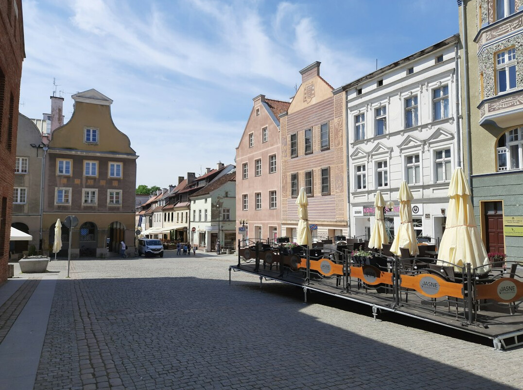 Old town square with cafe tables and pastel buildings