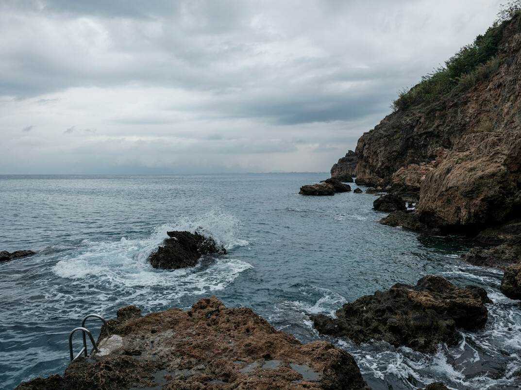 Rocky coastline with waves under an overcast sky